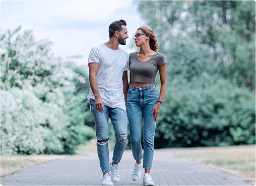 man and woman walking down street close together talking and smiling
